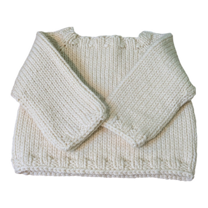 An off-white hand-knit baby sweater with a crew neck and long sleeves, arms folded neatly in front on a white background.